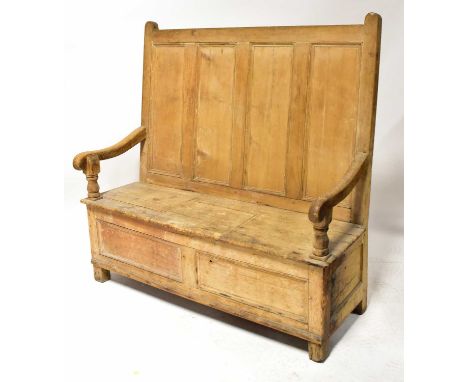 A late 18th/early 19th century rustic pine box seat settle, with four-panel back and later cut board to the centre section fo