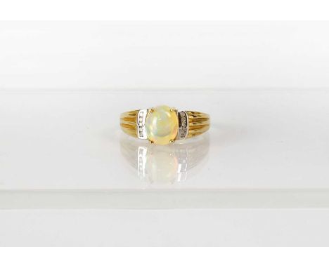 A 9ct yellow gold ring set with an oval opal cabochon, with a row of five tiny diamonds to each side, size V, approx. 3.6g.Co