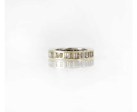 A white metal eternity ring set with baguette cut diamonds, size I, unmarked.Condition Report: - Approx. 4.7g.