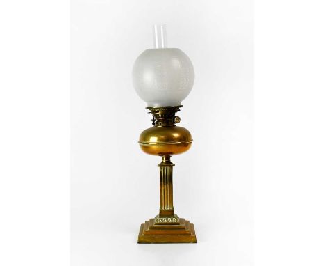 A brass oil lamp with etched glass shade, on a square reeded column, with heart motifs and stepped square base, height 65cm.