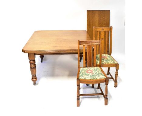 A Victorian oak wind-out dining table, with single additional leaf and canted corners, raised on turned supports to brass cap