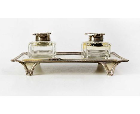 GOLDSMITHS &amp; SILVERSMITHS CO LTD; an Edwardian silver desk set of rectangular form with gadrooned and scroll borders, set