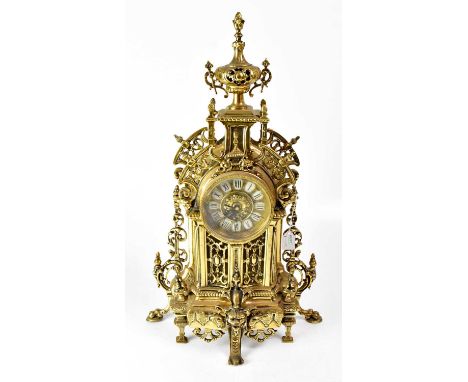 A French gilt brass cased mantel clock, with ornate pierce work decoration, the top surmounted by an urn, the dial set with i