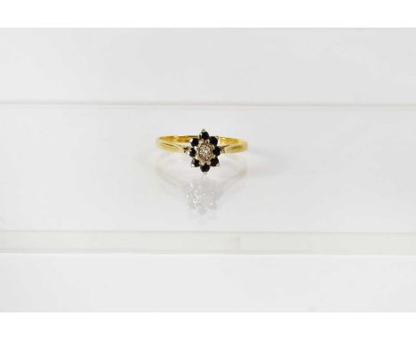 An 18ct yellow gold cluster ring set with a tiny diamond surrounded by eight sapphires, size R, approx. 2.9g.Condition Report