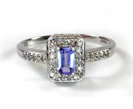 A 9ct white gold tanzanite and diamond set cluster ring with diamond set shoulders, (N.5).