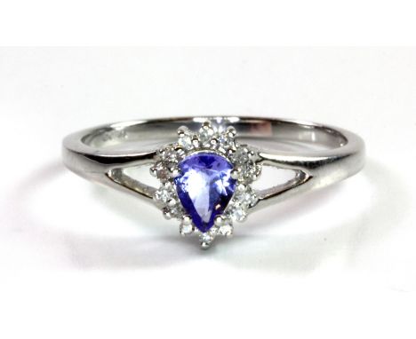 A 9ct white gold cluster ring set with a pear cut tanzanite and diamonds, (O.5).