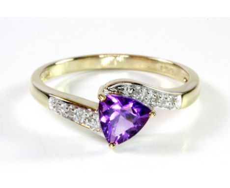 A 9ct yellow gold ring set with a trilliant cut amethyst and diamond set shoulders, (P.5).