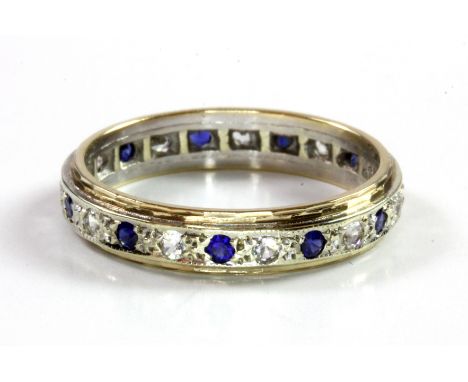 A 9ct yellow and white gold white spinel and sapphire set full eternity ring, (Q).