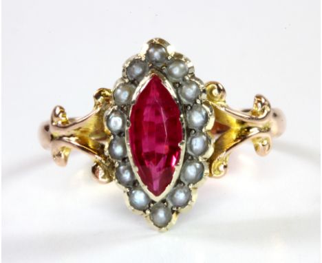 An antique 9ct yellow gold ring set with a marquise cut ruby surrounded by seed pearls, (O).