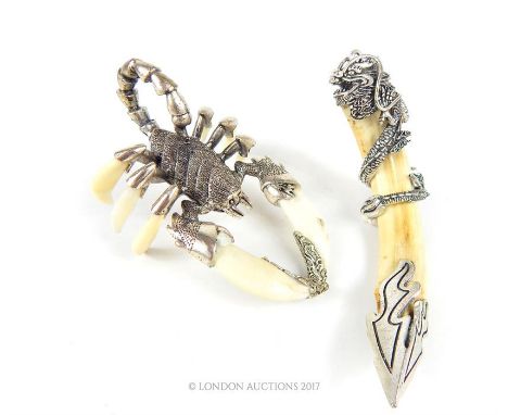 Two Chinese boar tusk and white metal ornaments, one in the form of a scorpion, 12cm long, the other in the form of crescent,