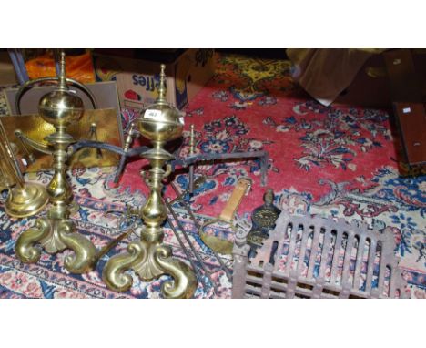 A cast iron dog grate; brass and cast iron and irons; a brass companion set; a brass magazine rack; a brass standard lamp