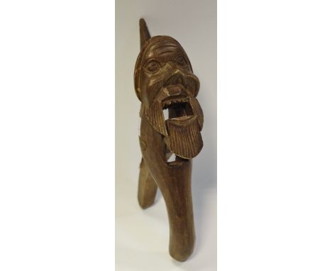 A Black Forest novelty lever-action nut cracker, carved as a bearded gnome wearing a pointed hat