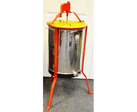 A CMF manual honey extractor, three sections raised on tripod feet 