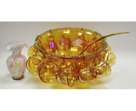 A carnival glass punch bowl, twelve cups and ladle; a mottled opaque glass vase, everted wavy rim