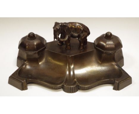 A continental spelter dark patinated inkstand, surmounted with a central naturalistically cast elephant, flanked by a pair in