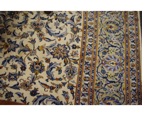 A Kashan carpet, the cream ground with flowers and foliage in tones of crimson and cerulean, 414cm x 300cm