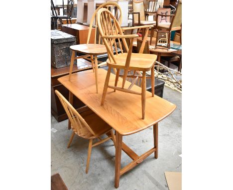 ERCOL; a mid century light elm refectory table raised on tapering block supports, height 73.5cm, length 136cm, depth 68cm and