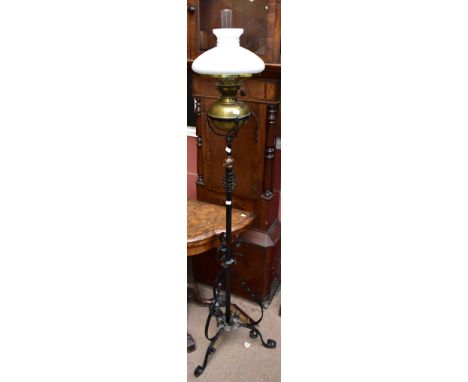 A Victorian wrought iron adjustable oil lamp on stand with detachable brass Messenger's patent reservoir, with milk glass sha