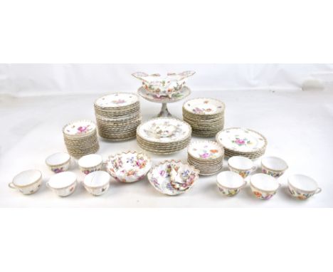 A matched late 19th/early 20th century Continental porcelain tea/dinner service decorated in enamels with flowers within gilt