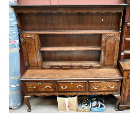 A Georgian style oak dresser, the plate rack back with two panelled doors and six spice drawers, the base section with three 