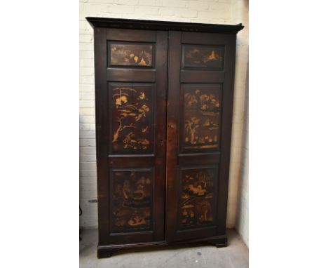 An unusual late 18th/early 19th century chinoiserie decorated wardrobe, the moulded dentil cornice above two panelled doors e