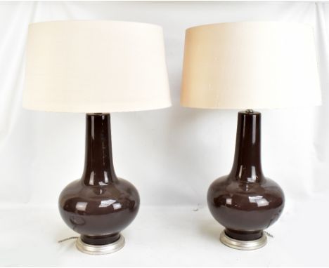 PORTA ROMANA; a pair of brown glazed ceramic bottle form table lamps on silvered circular bases, manufacturer's mark to under