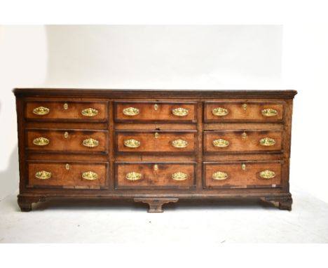 An 18th century oak dresser with an arrangement of nine drawers raised on bracket feet, height 94cm, length 211cm, depth 58cm