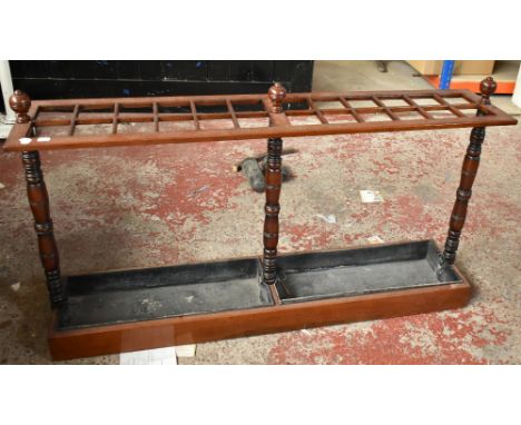 A late Victorian mahogany twenty four division rectangular stick stand with two drip trays, height 70cm, length 124cm, depth 