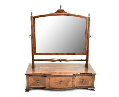 An Edwardian mahogany inlaid toilet swing mirror with brass finials and bevelled glass above three short drawers two ogee bra