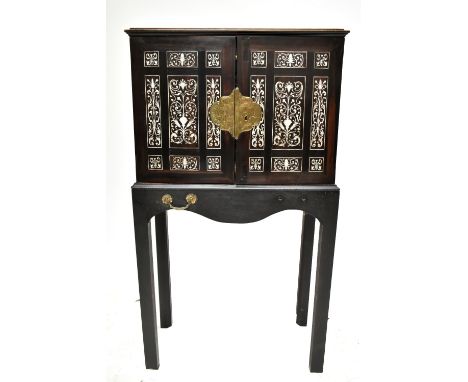 A late 17th/early 18th century Indo-Portuguese ebony and ivory inlaid cabinet on stand, the moulded top with recessed geometr