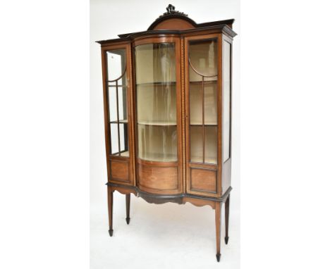 An Edwardian inlaid mahogany bow front display cabinet with twin glazed doors enclosing two fixed shelves, height 208cm, leng