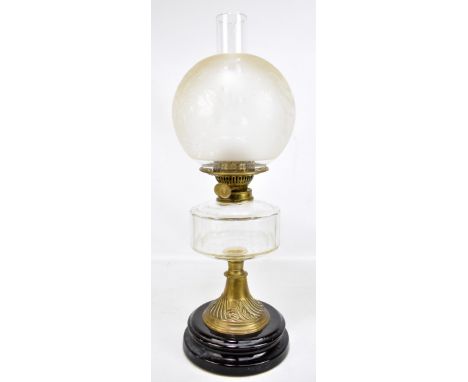 A 19th century oil lamp with foliate etched globular shade and chimney on clear glass reservoir to relief foliate detailed lo