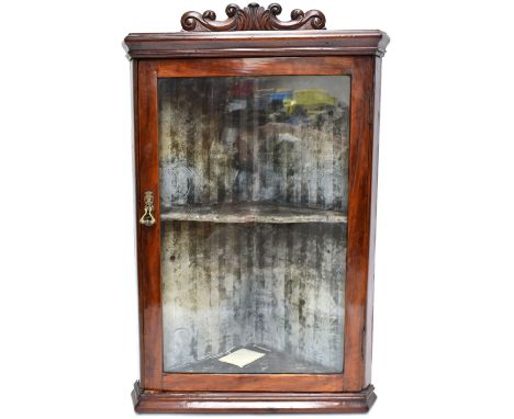 A late 19th/early 20th century stained pine hanging flat fronted corner cabinet, with carved cornice and green lined interior