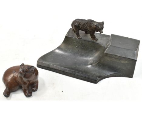 A late 19th/early 20th century spelter desk stand modelled with a stalking bear beside a hinged inkwell and above pen rest, u