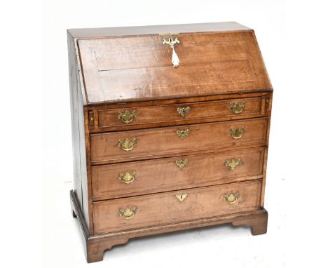 A Georgian style oak bureau of small proportions, the fall front enclosing fitted compartments above two short over three lon