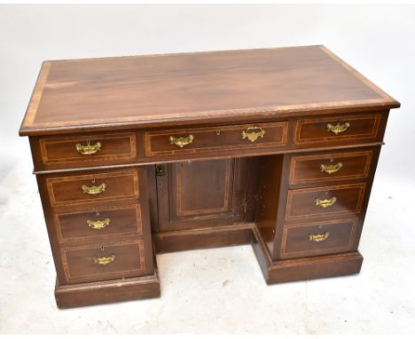An Edwardian inlaid mahogany knee-hole desk with an arrangement of nine drawers surrounding a set of cupboard doors, height 7