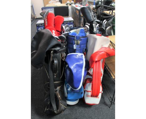 Three golf bags containing assorted clubs including a set of Wilson Cobra irons, set of Howson irons, Hippo drivers etc