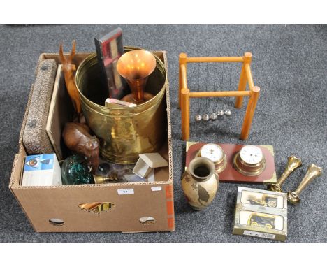 A box containing brass coal bucket, ship's style barometer and clock, wooden figures, glass paperweight, Newton's cradle, cas