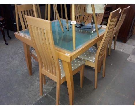 A light wood glass table top table with chairs.  