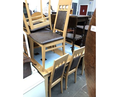 A light wood and glass extending dining table and six chairs.  