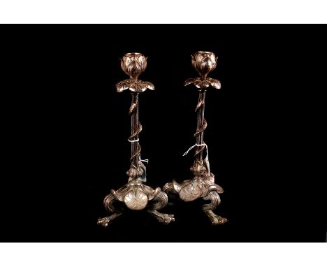 A pair of silver plated serpent and flower bud candlesticks with lily pad decortation over webfooted tripartite bases (2)some