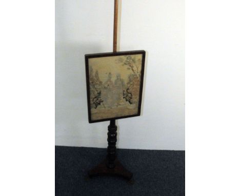 A Victorian mahogany pole fire screen, triform base with brass feet supporting turned shaft with embroidered panel in mahogan