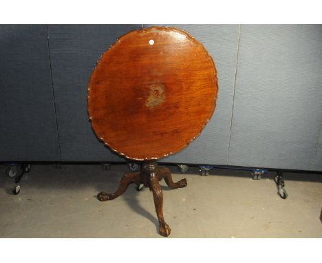 A George III period Irish mahogany ocassional table, having carved tripod base with ball and claw feet and a later pie crust 