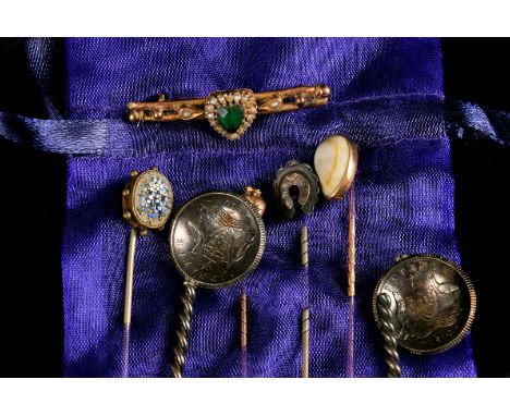 A small collection of stick pins, including one decortaed in micromosaics with a flower bouquet, a brooch with heard shaped s