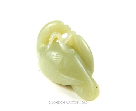 A Chinese jade figural group carved with two birds holding a branch between them, 4 x 6 x 3.5cm.
