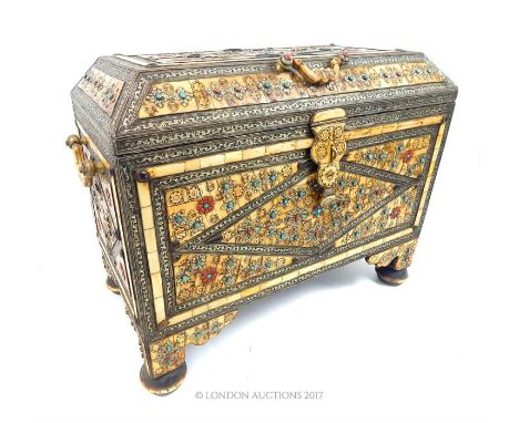 A North African twin handled trunk, inlaid with bone and embossed white metal, mounted with polished turquoise and red semi p