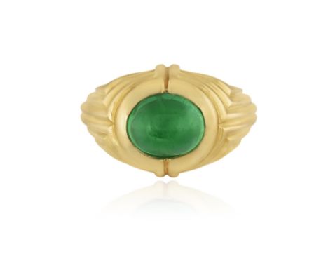 BULGARI: AN EMERALD DRESS RINGOf reeded design, centring a collet-set oval-shaped emerald cabochon weighing approximately 3.8