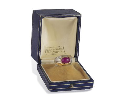 BULGARI: A RUBY DRESS RINGThe bi-coloured bombé and reeded mount centring an oval-shaped ruby cabochon, within collet-setting