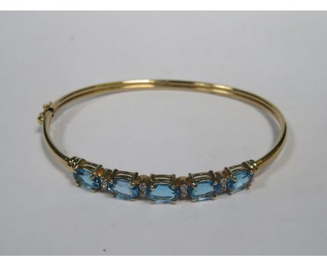 9k GOLD SNAP BANGLE SET WITH AQUAMARINE COLOURED STONES AND TEN CLEAR STONES 