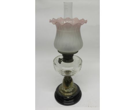 Oil lamp with brass column and glass reservoir with pink shade   